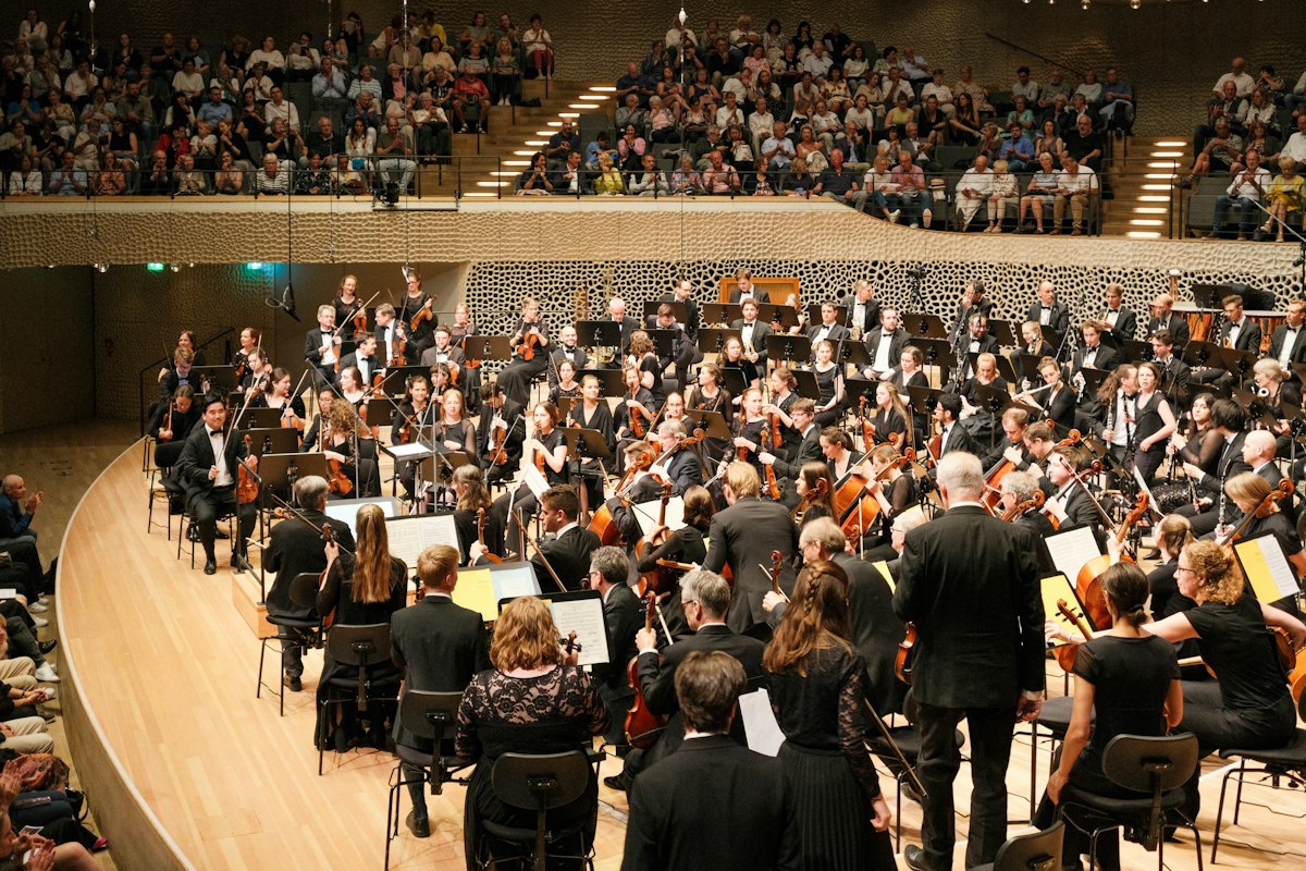 Orchester auf einer Konzertbühne mit Publikum